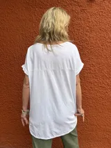 Blusa blanca de manga corta, con frente de seda y espalda de viscosa con elastano. Presenta cuello redondo y diseño holgado.