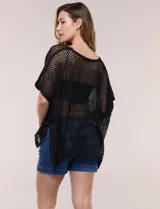Poncho de tejido calado color beige, con mangas cortas, aberturas laterales y lazos ajustables en el cuello. Modelo Do Everything In Love.