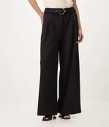 Pantalón wide leg de tiro alto color negro, confeccionado en crepé con elastano. Cuenta con perneras amplias, caída fluida e incluye un cinturón del mismo tejido con hebilla metálica grande.
