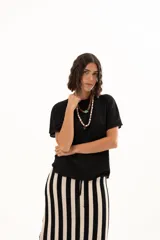 Blusa de textura arrugada en color negro, con cuello redondo y mangas cortas de corte holgado.