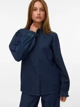 Camisa de denim de corte recto y color azul oscuro, con cuello alto con volados, cierre frontal de botones y mangas largas con puños elásticos fruncidos.