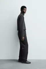 Pantalón chino de corte oversized confeccionado en tejido de algodón con estructura twill. Presenta bolsillos frontales, bolsillos traseros de vivo y cierre frontal con cremallera y gancho metálico oculto.