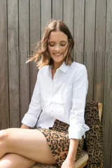 Camisa blanca de lino, de corte clásico, con cuello camisero, manga larga y bolsillo en el pecho.