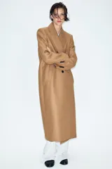 Abrigo largo negro ZARA Woman Collection de corte recto, confeccionado con hilatura de lana. Presenta cuello con solapa de muesca, cierre cruzado de doble botonadura frontal y bolsillos ribeteados en los laterales.