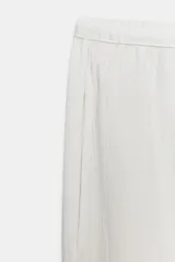 Pantalón de tiro medio con cintura elástica ajustable mediante cordones. Presenta un diseño fluido con bolsillos laterales ocultos y bajo decorado con una aplicación de encaje a contraste.