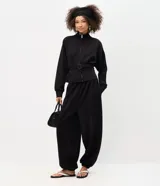 Pantalón balloon de modal color negro, con diseño amplio en las piernas, tiro alto y puños ajustados en los tobillos.