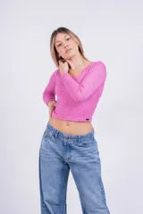 Remera corta color marrón con estampado animal print de leopardo, escote asimétrico y manga larga.