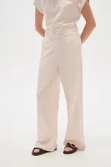 Pantalón de viscosa color verde militar, de corte ancho y tiro alto, con detalle de plisado en la cintura.