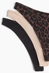 Pack de tres bombachas tipo thong de microfibra, tiro bajo con cintura en V y refuerzo interior. Incluye una negra, una beige y una con estampado de leopardo.