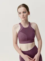 Top deportivo color borgoña, de sujeción media alta, con tejido Shape_Tech y espalda deportiva. Diseño elegante con combinación de tejido acabado satinado.