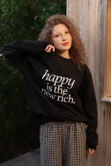 Buzo de cuello redondo gris melange con estampa frontal en negro con la frase "happy is the new rich".