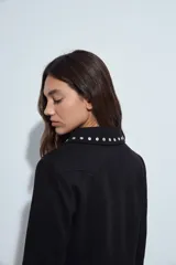 Campera estilo biker de símil gamuza color marrón, con cierre frontal y detalles de tachas metálicas en solapas, mangas y ruedo.
