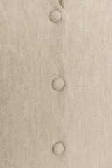 Chaqueta entallada de punto con escote en pico y manga larga. Presenta un diseño con bajo en evasé tipo peplum y cierre frontal con botones forrados a tono.