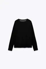 Jersey de punto liso, color azul brillante, con cuello redondo y manga larga. Presenta acabados en rib en puños, cuello y bajo, con aberturas laterales en el ruedo.