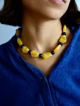 Collar de diseño artesanal compuesto por cuentas de resina en tonos amarillo y azul, con formas irregulares y esféricas.
