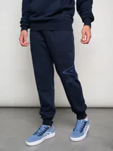 Pantalón de jogging azul marino de felpa con puños elásticos y logo de la marca estampado en la pierna izquierda.