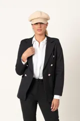 Blazer cruzado negro, entallado, con doble fila de botones dorados en relieve en el frente.