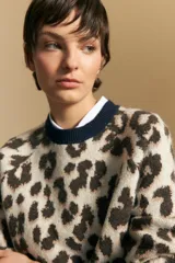 Sweater de tejido jacquard con estampado animal print, de silueta relajada y manga larga. Presenta cuello redondo y bordes en contraste de color bordó.