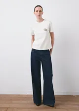 Remera de algodón blanca de corte recto con cuello redondo, manga corta y pequeño estampado en el pecho con la inscripción "Flower Market".