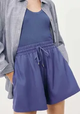 Short de lino color lila, con cintura elástica y cordón ajustable. Presenta un corte holgado y cómodo.