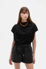 Short cargo negro de poliéster, con cintura elástica fruncida y cordón ajustable. Posee bolsillos laterales tipo cargo.