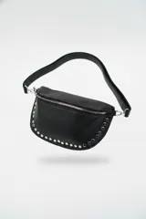 Cartera tipo riñonera o bandolera de cuero sintético negro con textura granulada, forma de media luna y detalles de tachas plateadas en el borde inferior. Cuenta con cierre metálico plateado y correa ajustable.