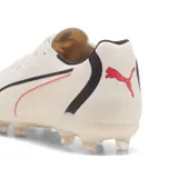 Championes de fútbol Puma modelo King 2.0 Match FG/AG, color arena con franja lateral característica en negro y detalles en rojo neón. Diseñados para césped natural firme y artificial.