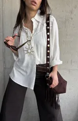 Camisa blanca de manga larga con detalles bordados en el canesú y cuello clásico.