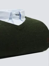 Buzo de lana con escote en V, color gris, de manga larga y diseño clásico con puños y dobladillo acanalados. Presenta un pequeño logo bordado en el pecho.