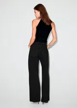 Pantalón de jean estilo wide leg con cintura cruzada y cierre frontal asimétrico. Cuenta con cinco bolsillos y trabillas para cinturón.