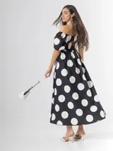 Vestido largo de lunares con escote bote y hombros descubiertos, mangas cortas abullonadas, cuerpo con nido de abeja y falda amplia.
