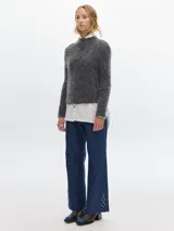 Polera azul de tejido suave con cuello alto y manga larga. Tiene un pequeño bordado en el frente y otro en la manga.