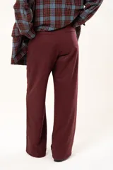 Pantalón de vestir color bordó, de corte recto y tiro alto, con bolsillos laterales y cierre frontal con botón.