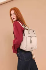 Cartera mochila de diseño versátil, color rosado, confeccionada en material sintético impermeable. Cuenta con doble asa superior, correas ajustables para usar como mochila, compartimento principal con cierre y bolsillo frontal con cierre decorado con tirador largo.