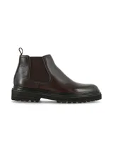Bota tipo Chelsea de cuero color marrón oscuro, con paneles elásticos laterales y suela de goma dentada estilo track.