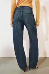 Jeans de tiro medio confeccionados en denim con efecto lavado, diseño de pernera curva y corte recto. Cuenta con cinco bolsillos, trabillas en la cintura y cierre frontal con cremallera y botón metálico.