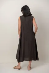 Vestido midi de lino color verde militar, sin mangas, con escote buche y bolsillos laterales, de corte relajado y fluido.