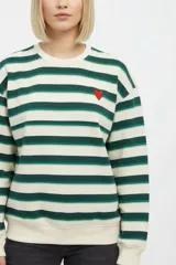 Buzo de cuello redondo a rayas horizontales en tonos beige, verde oscuro y verde claro, con un pequeño bordado de corazón rojo en el pecho.