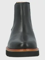 Botín Chelsea de cuero negro, estilo botín corto, con elásticos laterales y suela plataforma gruesa de goma con borde de cuero marrón y costura visible.