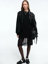 Blazer de ecocuero negro con silueta estructurada, solapas clásicas y cierre frontal mediante botones.