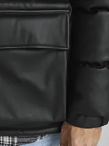 Campera puffer negra de cuero sintético con cierre frontal y cuello alto.