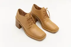 Zapato acordonado de cuero color marrón chocolate, con punta cuadrada y tacón ancho.