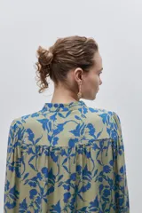 Camisa de calce amplio y fluido de viscosa liviana, con estampado de rayas verticales irregulares en blanco y negro, cuello mao, abotonadura frontal y mangas largas.