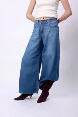 Pantalón de jean estilo wide leg, de tiro medio y corte holgado, confeccionado en denim de algodón.