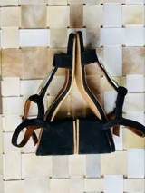 Sandalias de gamuza azul marino, de taco bajo, con tira en forma de T adornada con una placa central de nácar y alpaca, y tira ajustable al tobillo.
