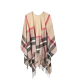 Poncho abierto de tejido de punto con diseño de cuadros escoceses en tonos beige, negro, blanco y detalles en rojo. Presenta terminaciones con flecos en el ruedo.