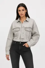 Campera cropped de jean en color gris lavado, con diseño de corte holgado, mangas amplias, cuello clásico y cierre frontal con botones metálicos. Incluye dos bolsillos frontales con solapa.