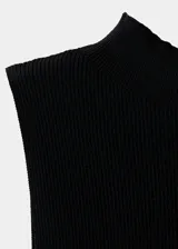 Top negro de punto con cuello perkins, sin mangas, diseño entallado y detalle de volante en el bajo.
