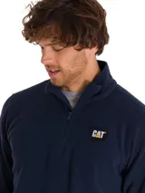 Buzo polar de microfibra color azul marino, con cuello alto y cierre frontal de cuarto de longitud. Presenta el logo de la marca Caterpillar aplicado en el pecho.