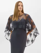 Vestido largo de corte sirena en color azul marino, confeccionado en tejido de punto con caída fluida. Presenta una capa integrada de tul fino sobre los hombros y espalda, decorada con bordados florales a tono y lentejuelas brillantes. Posee escote redondo y cierre invisible en la espalda.
